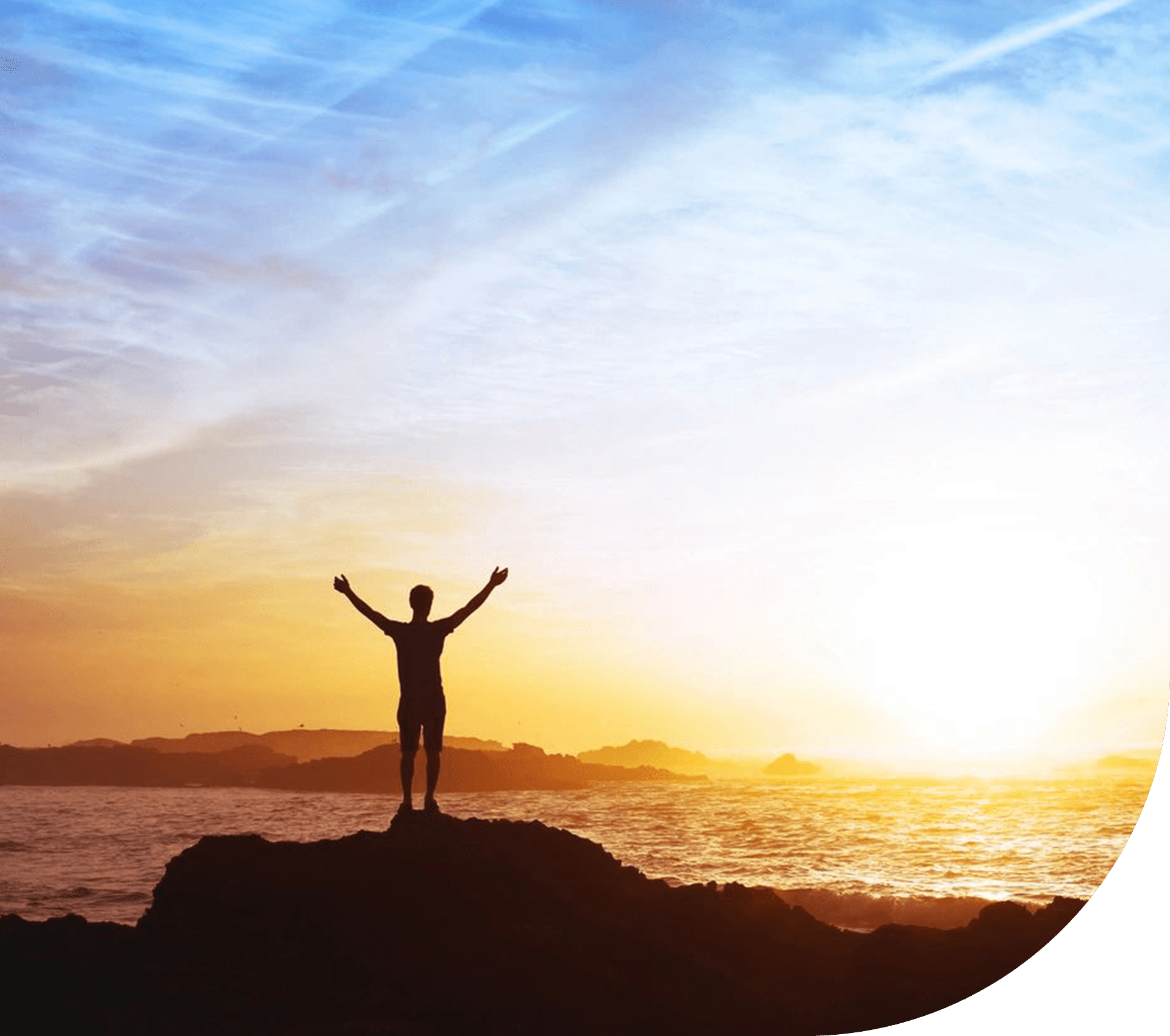A person standing on top of a rock near the ocean.